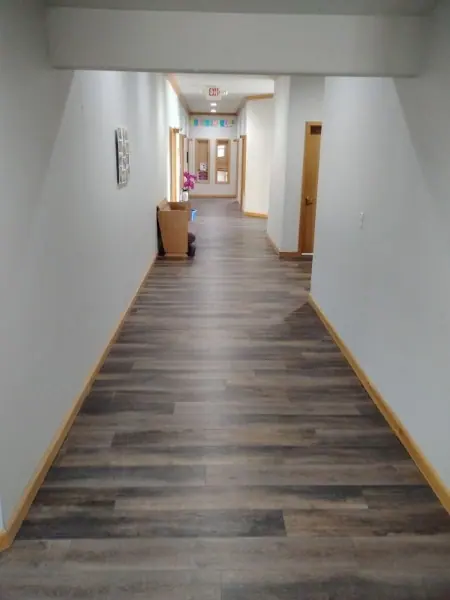 Completed wood-look commercial flooring installation in a long hallway in Hermiston, Oregon